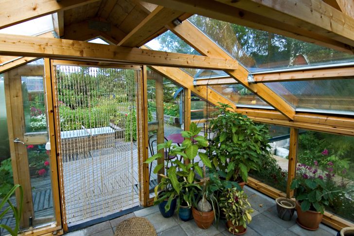 Inifrån växthuset ser man ut över köksträdgården med de upphöjda odlingsbäddarna och det vackert lagda trägolvet som Kurt Ove gjort.