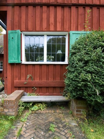 En bänk in mot husväggen tar minimalt med plats och blir tidigt varm om våren. Med omgivande tegelmurar, som här i Emma Lundbergs (1869–1953) trädgård på Lidingö, får man fina avställningsytor för kaffekoppen och frukostsmörgåsen.