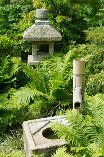Lanterna och stenskål med bamburör för vattnet, japanska prydnader med ursprung i te-ceremonin.