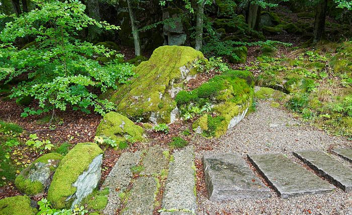 Beroende på inlandsisen så har naturen och stenarna fått mjukare former här i Norden än i Japan. I den japanska trädgården i Ronneby brunnspark verkar grusbäcken ha sin källa bakom stenen i centrum, för att sedan fortsätta mellan de flata stenarna som korsar loppet.