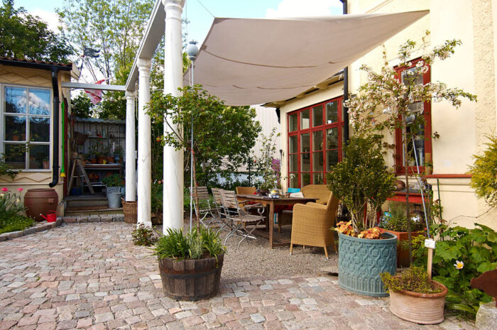 En fyrkantig matplats med segelduk till tak och grus till golv