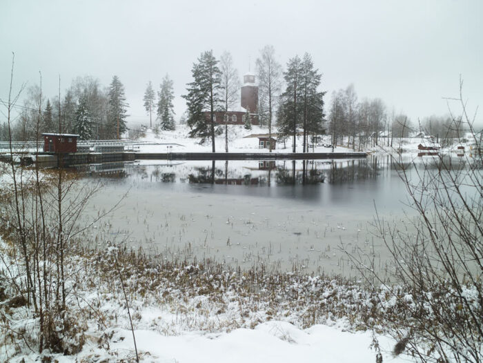 Första snön runt dammen i Lagfors, med Gustaf kyrka i bakgrunden.